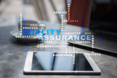 Kalite güvencesi kavramı sanal ekran üzerinde. İş kavramı. Kelime bulutu.