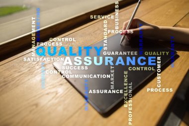 Kalite güvencesi kavramı sanal ekran üzerinde. İş kavramı. Kelime bulutu.