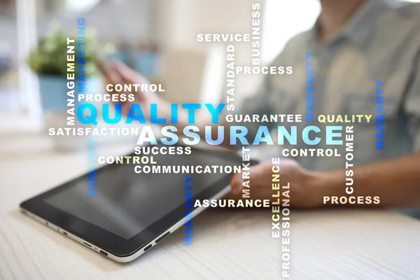 Kalite güvencesi kavramı sanal ekran üzerinde. İş kavramı. Kelime bulutu.