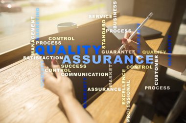 Kalite güvencesi kavramı sanal ekran üzerinde. İş kavramı. Kelime bulutu.