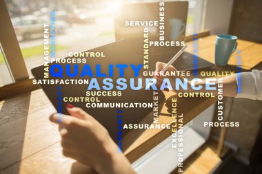 Kalite güvencesi kavramı sanal ekran üzerinde. İş kavramı. Kelime bulutu.