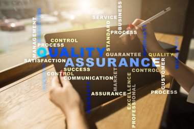 Kalite güvencesi kavramı sanal ekran üzerinde. İş kavramı. Kelime bulutu.