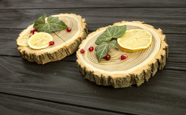 Zagen van hout met met plakjes citroen en granaatappel bessen — Stockfoto