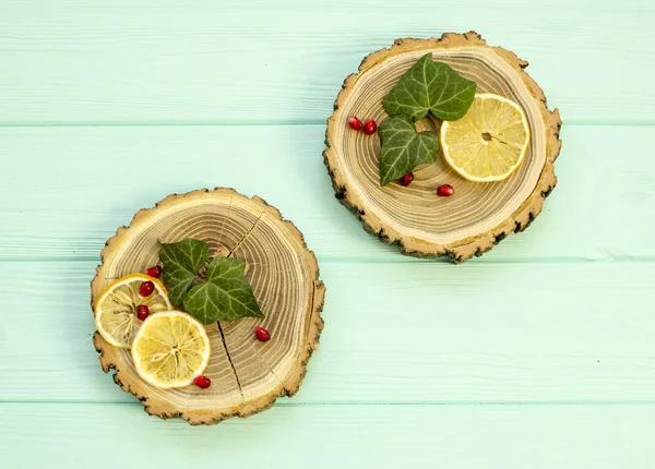 Zagen van hout met met plakjes citroen en granaatappel bessen — Stockfoto