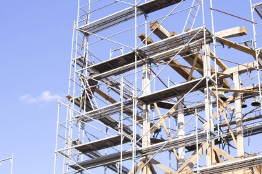 high scaffolding against blue sky clipart