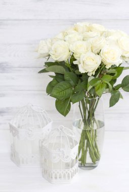 Cam vazo içinde sunulan yaprakları ile şık beyaz gül buketi.
