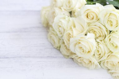 Beyaz ahşap masa üzerinde beyaz gül buketi. 