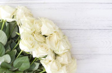 Beyaz ahşap masa üzerinde beyaz gül buketi. 