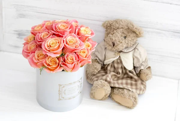 Roses in a round box and plush bear. Romantic gift.