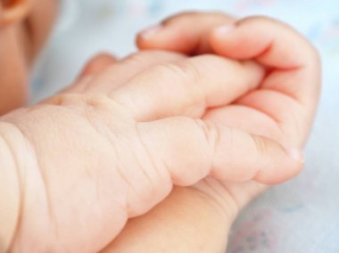 Yeni doğmuş bebek elinin yakınına.
