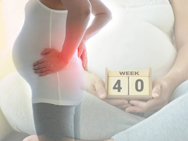 Gravid kvinna med ryggsmärtor på 40 veckor. Begreppet graviditet vård. Stockbild
