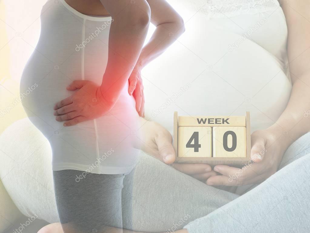 Pregnant woman with back pain on 40 weeks. Concept of pregnancy healthcare.
