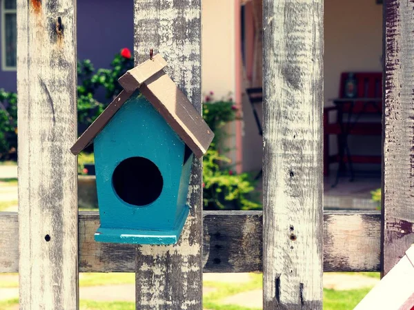 Vecchia casa di uccelli o scatola nido pende sulla recinzione di legno . — Foto Stock