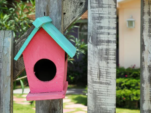 Vecchia casa di uccelli o scatola nido pende sulla recinzione di legno . — Foto Stock