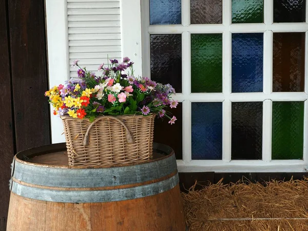 Fiori sulla vecchia botte di legno sopra la finestra per la decorazione domestica — Foto Stock