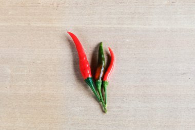 Ahşap arka plan üzerinde kırmızı biber parlak renkler