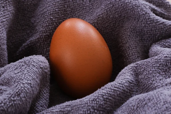 Свіже коричневе куряче яйце на тканині крупним планом — стокове фото