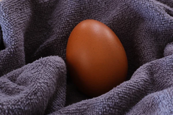 Свіже коричневе куряче яйце на тканині крупним планом — стокове фото