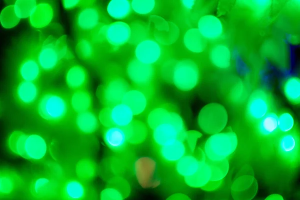 Bokeh licht groene defocus bij nacht abstracte achtergrond closeup. — Stockfoto