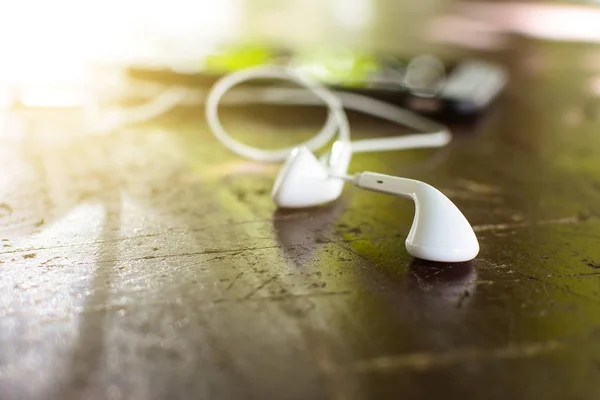 White earphone on desk with soft light