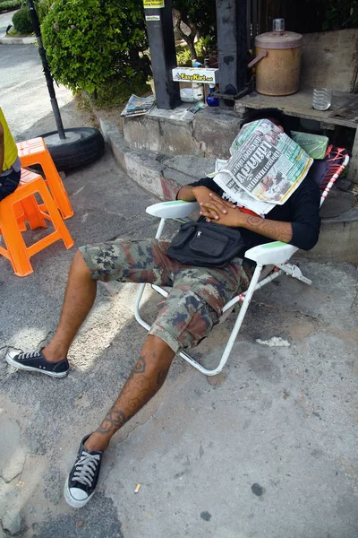 Relájate. El hombre descansando en la calle cubriéndose la cara con un periódico . — Foto de Stock