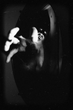 Mistik portre. Adam aynaya dışarı tırmanıyor.