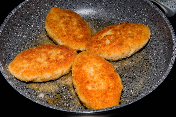 Bir tavada ev yapımı kızarmış balık köftesi.