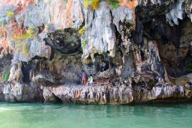 Pitoresk ve olağandışı kayalık sahildeki turistler.