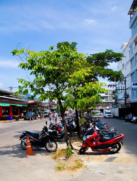 Scooters motor estão estacionados sob árvores ao lado do mercado . — Fotografia de Stock