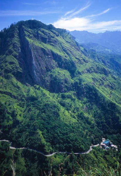 Paisagem de montanha com uma estrada sinuosa abaixo. — Fotografia de Stock