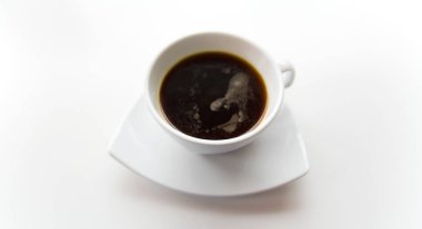 Beyaz bir daire üzerinde beyaz bir fincan sade kahve.