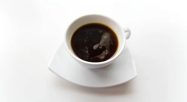 Black coffee in a white cup on a white saucer. — Stock Photo, Image