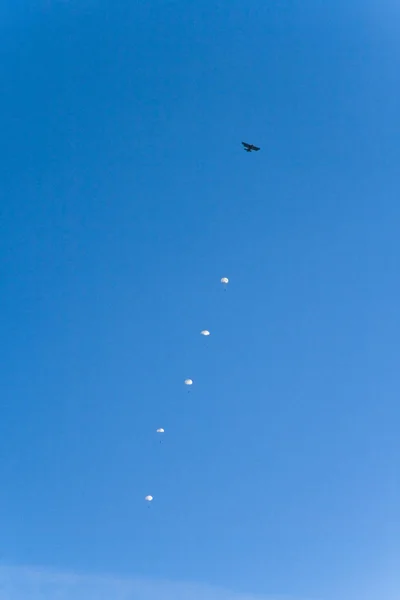 Ett litet flygplan och fallskärmar i himlen. — Stockfoto