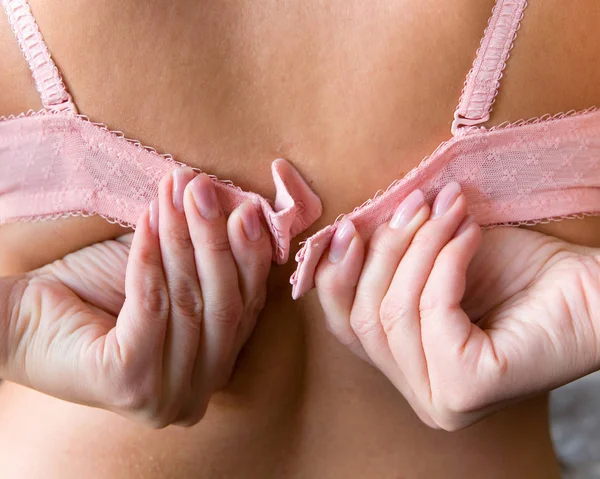 Le belle mani delle donne con una manicure slacciano il reggiseno . — Foto Stock