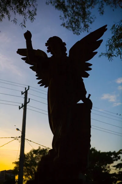 Silhouette eines Engels auf einem Grabstein auf dem Friedhof. — Stockfoto