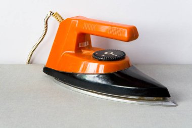 Eski bir pişmiş toprak demir renkli bir ışık kumaş üzerine duruyor.