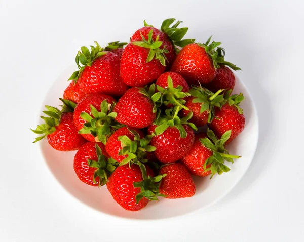 Berries of a strawberry on a white plate.