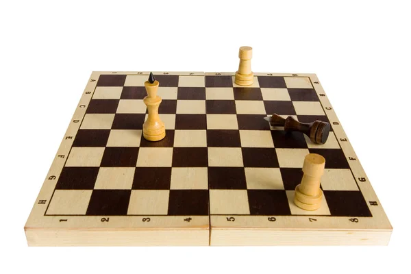 The black chess king is defeated and lies on the board. Stock Image