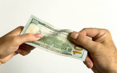 Bir erkek ve bir kadının el 100 dolar tutun.