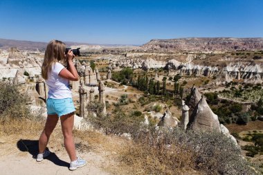 Bir kız bir dağ manzarası resimleri alıyor.