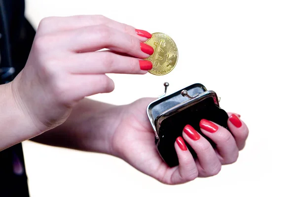 Eine schöne weibliche Hand versteckt den Bitcoin in einer Handtasche. — Stockfoto