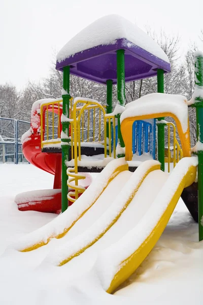 Scivolare nel parco giochi sotto uno spesso strato di neve . — Foto Stock