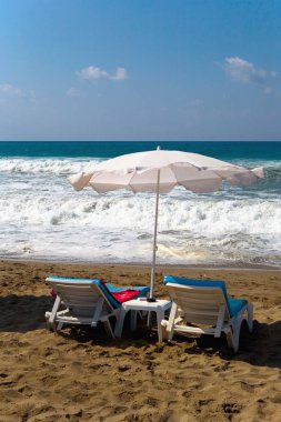 Güneş yataklar sahilde küçük bir fırtına sırasında vardır.