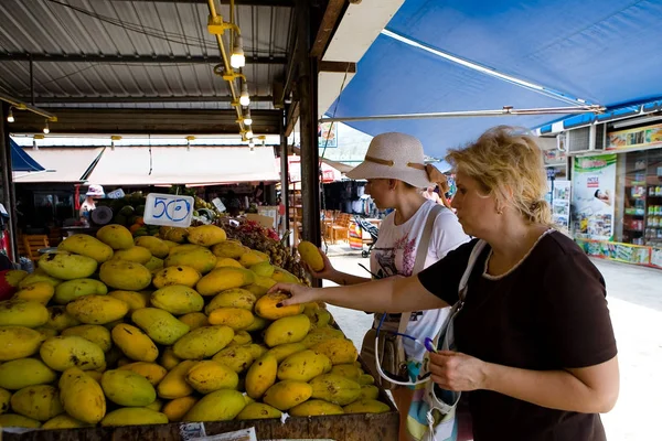 I turisti europei scelgono i manghi nel mercato . — Foto Stock