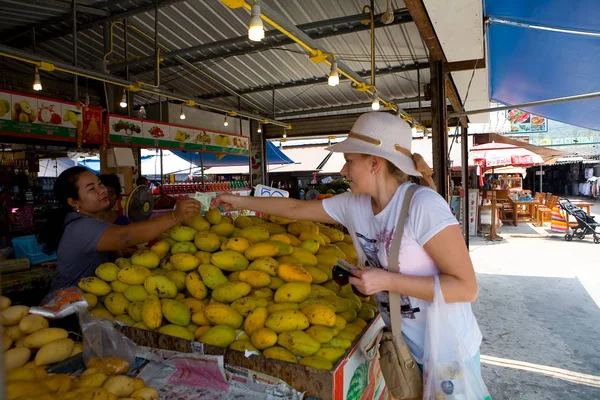 Una ragazza europea compra manghi nel mercato . — Foto Stock