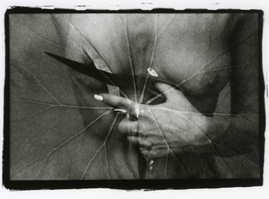 Bir kadın eli makas tutan ve göğüs ucunu medet umuyor.