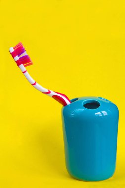 Sarı bir arka plan üzerinde güzel çok renkli diş fırçası.