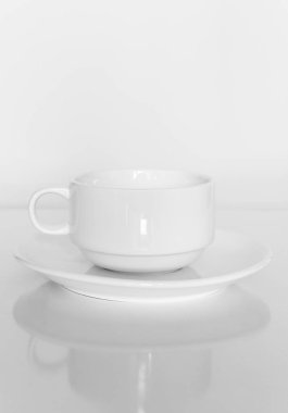 Beyaz bir arka plan üzerinde beyaz bir plaka üzerinde beyaz kahve fincanı.