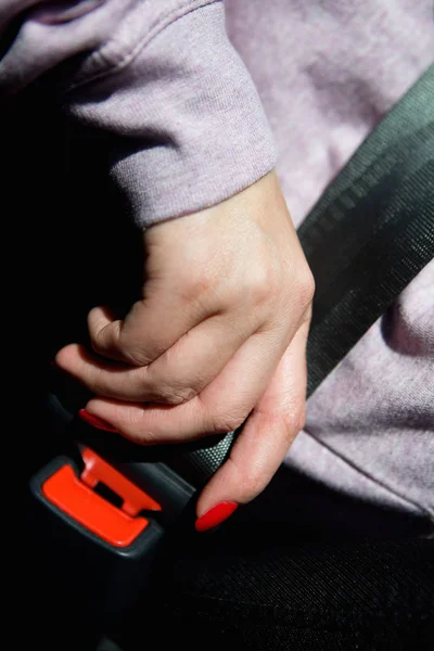 A mão de uma mulher com uma bela manicure prende o cinto de segurança . — Fotografia de Stock