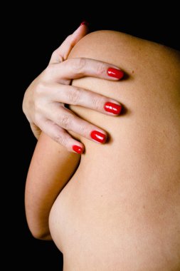 Güzel bir kadının el çıplak omzuna yatıyor. 